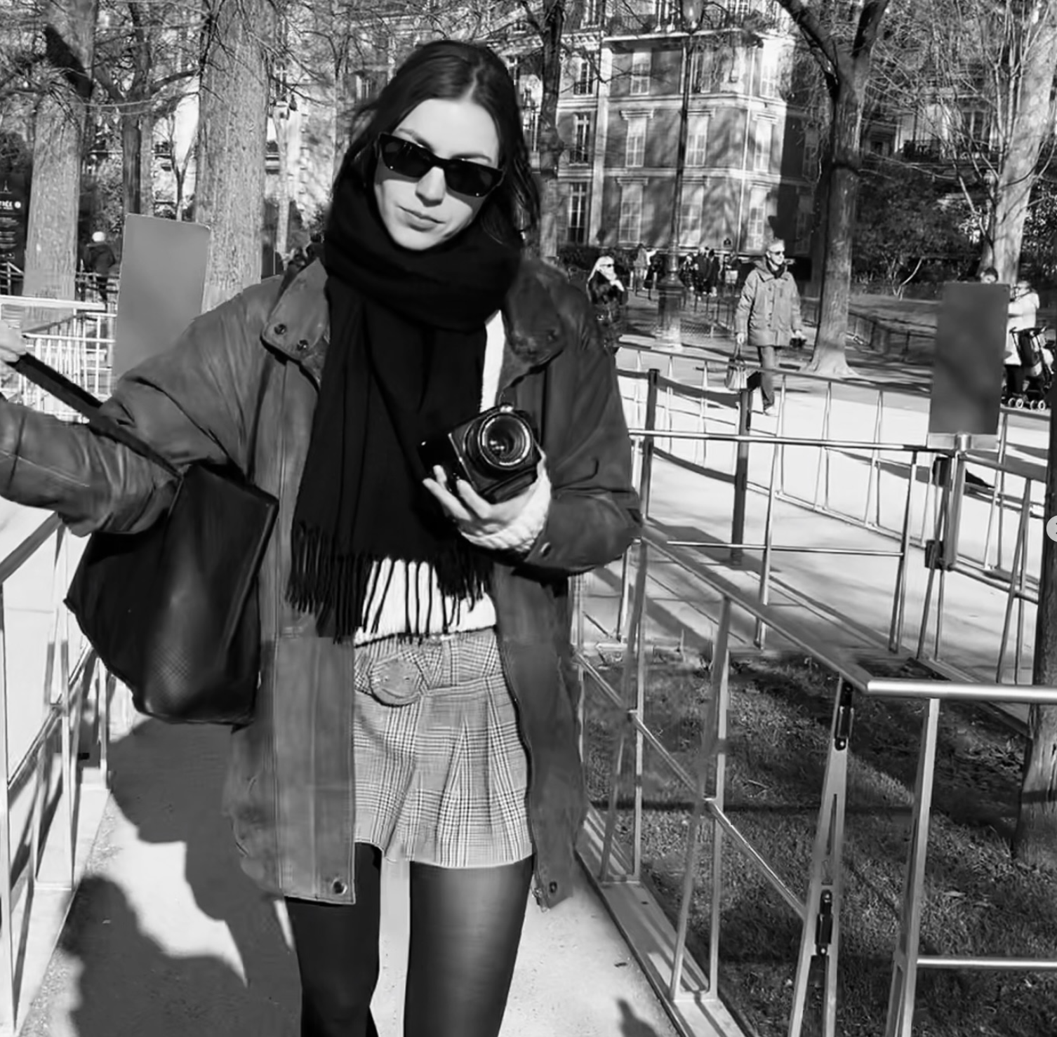 Diana Manolova holding her camera on a sunlit Paris street